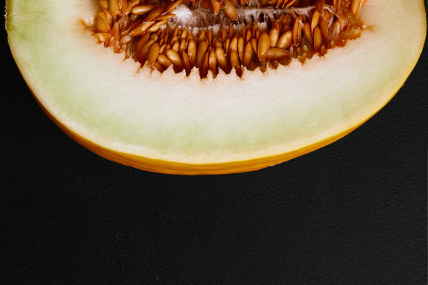 工作室拍摄的缺口成熟瓜加利亚孤立的黑色背景图片下载