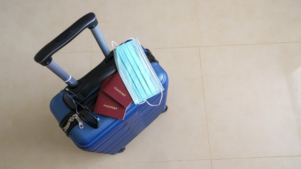 新冠肺炎大流行期间用于旅行的蓝色行李箱。概念假日和旅行。横幅的尺寸。副本的空间。有选择性的重点。景深浅图片下载