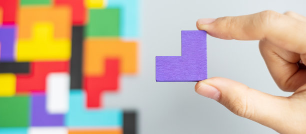 手连接几何形状块与彩色的木材拼图块。逻辑思维，商业逻辑，难题，决策，解决方案，理性，任务，成功，目标和战略概念图片下载
