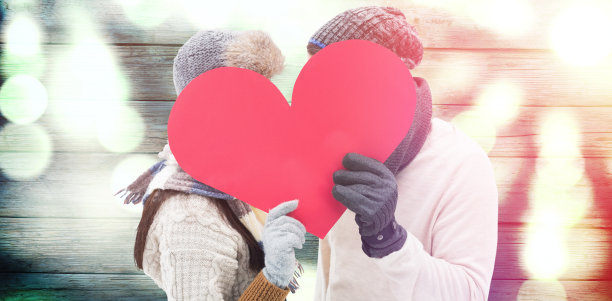 复合形象的迷人的年轻夫妇在温暖的衣服抱着红色的心图片下载