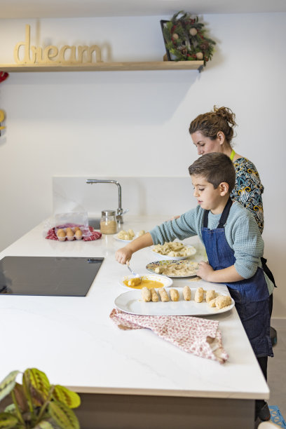 母亲和儿子在厨房做炸丸子图片下载