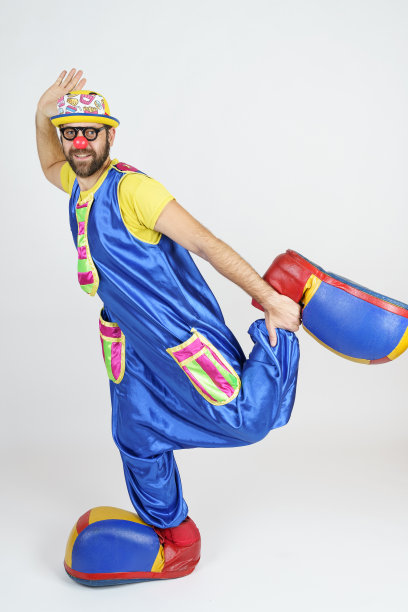 小丑是一个穿着亮蓝黄相间的衣服，戴着眼镜和帽子的男人，感情用事。图片下载