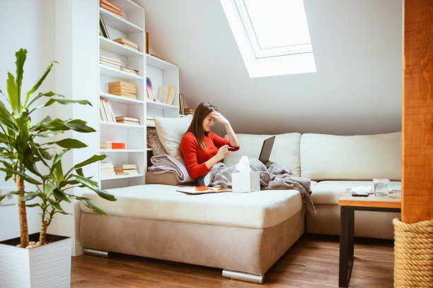 病人坐在家里的沙发上测量体温图片下载