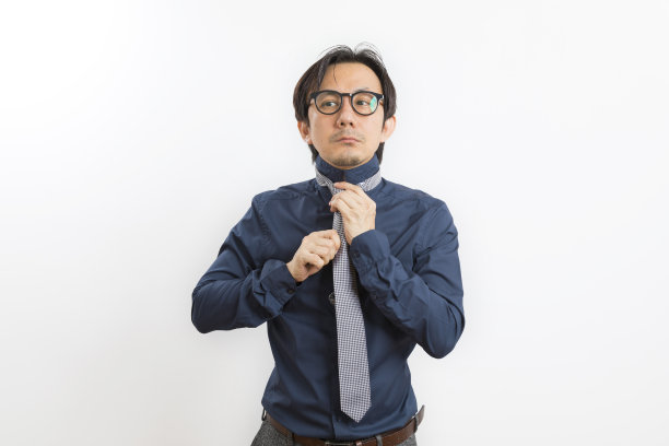 穿着黑色衬衫的中年亚洲男人正打扮和调整脖子上的领带。图片下载