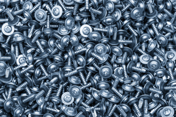 浅蓝色场景中的一堆垫圈头螺钉。特殊的螺杆零件制造理念。图片下载