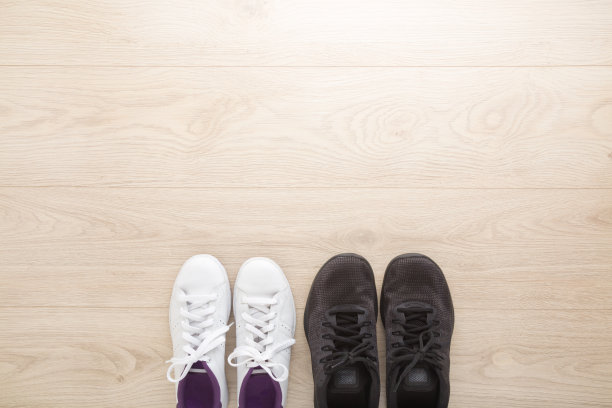 白人女性和黑人男性运动鞋步行，跑步或健身木地板背景。特写镜头。空的地方为激励，鼓舞人心的文本，引用或语录。自顶向下的观点。图片下载