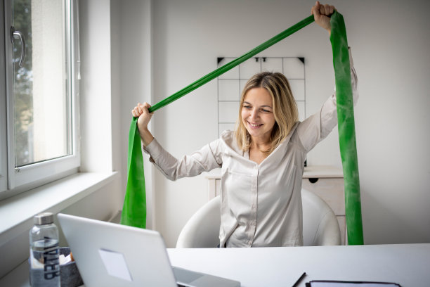 工作和生活的平衡:商业女性工作和运动在她的办公室与健身手环图片下载