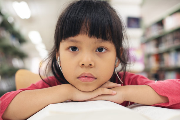 一个微笑的亚洲小女孩的肖像。孩子们微笑着看着相机图片下载