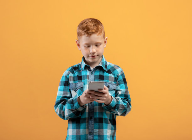 可爱的姜黄色小孩，手机是黄色的图片下载