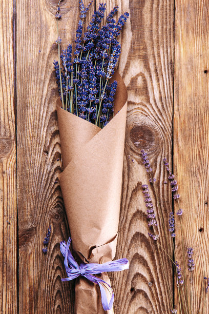 牛皮纸上的薰衣草花束，木质背景俯视图垂直照片图片下载