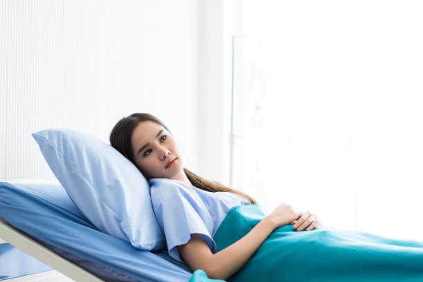 一名亚洲年轻女性患者焦虑地躺在病房的床上。图片下载
