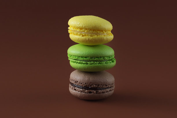三个新鲜美味的法式马卡龙，在棕色的背景上。一堆巧克力、苹果和柠檬布朗尼蛋糕。明亮的令人垂涎的零食。横向照片，大计划。图片下载