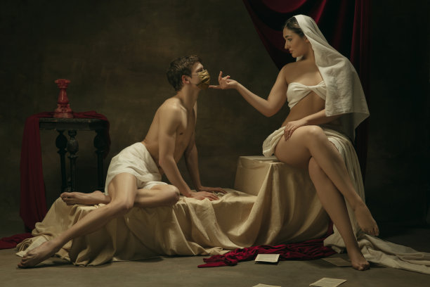 以冠状病毒为主题的经典艺术品的现代翻拍——黑暗背景上的中世纪年轻夫妇图片下载