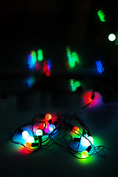 五彩缤纷的花环以一颗心的形式映在窗户上的深色背景上，呈垂直状图片下载