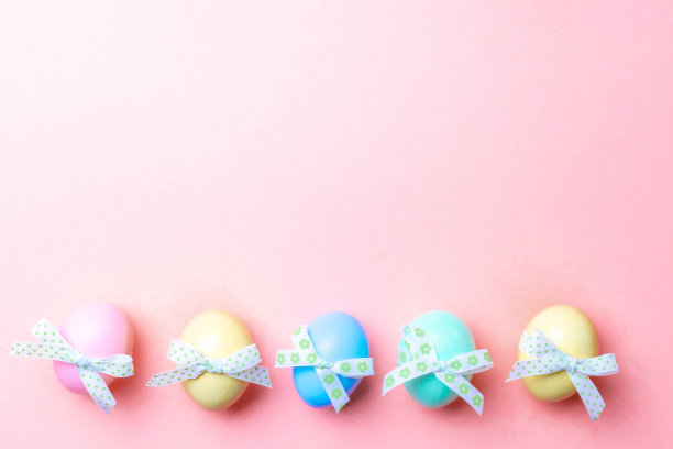 复活节假期。彩色彩蛋与彩带在粉红色的背景在快乐复活节装饰。春假顶视图与拷贝空间。图片下载