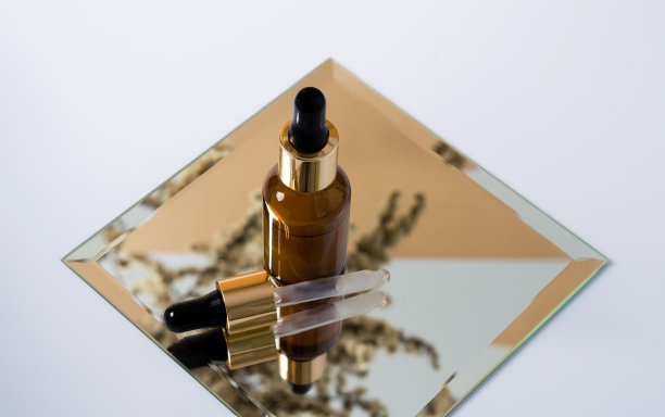 镜子上的血清瓶上有一株植物在白色背景的镜子上的倒影图片下载