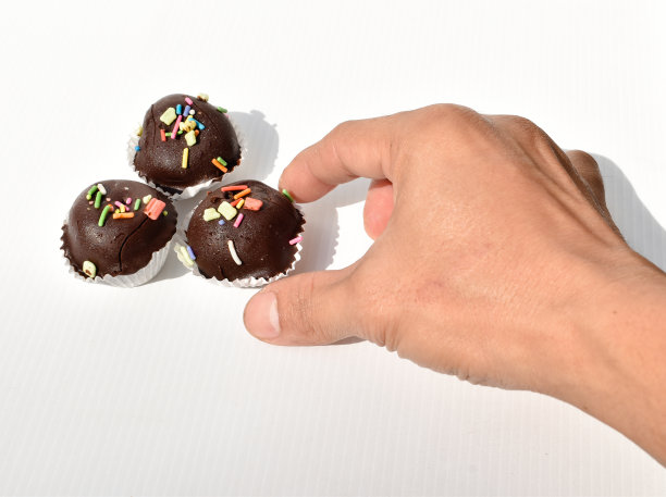 白色背景上的巧克力球和手图片下载