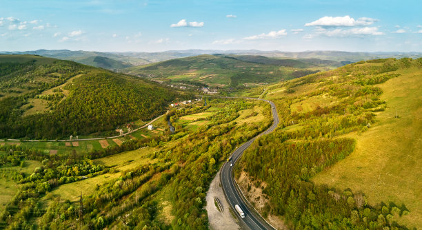 在山区高速公路。夕阳照在山上。春绿田园山水。图片下载