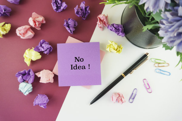 采购产品Sticky Notes, Pen, Crumpled Paper and Paper Clips on Multi - color Background。图片下载