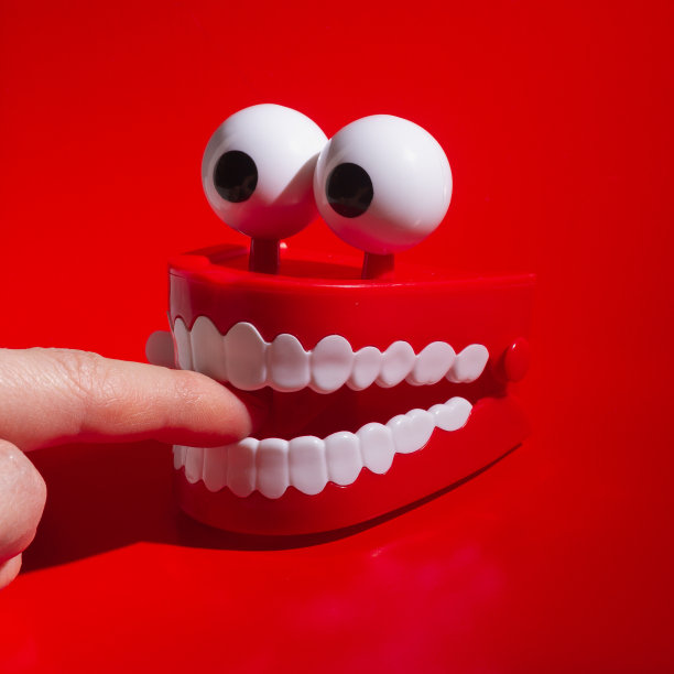 用锋利的牙齿把手指放进嘴里，用玩具下巴咬手指图片下载