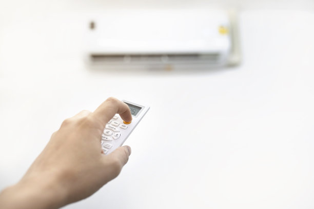 用遥控器手动关闭空调。节能概念图片下载