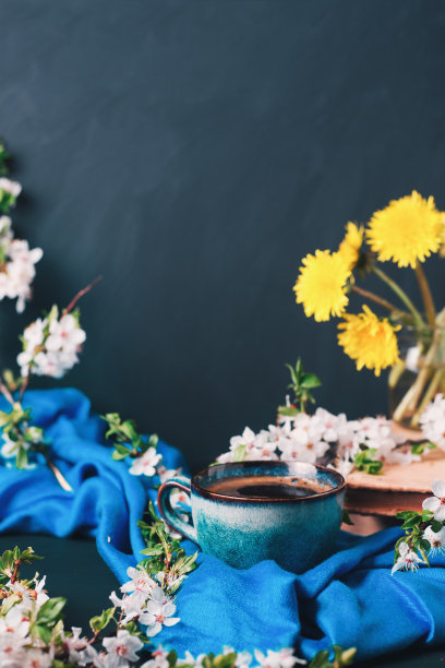 垂直照片春天卡，陶瓷杯茶或咖啡桌上，樱花枝，旧书，黄色蒲公英在一个玻璃，复古色调图片下载