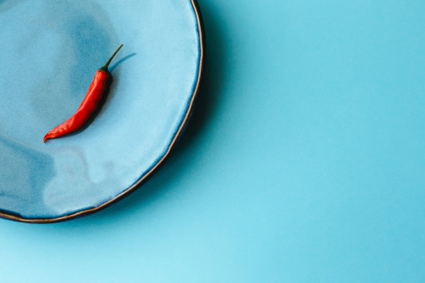 蓝色盘子里放着红辣椒。图片下载