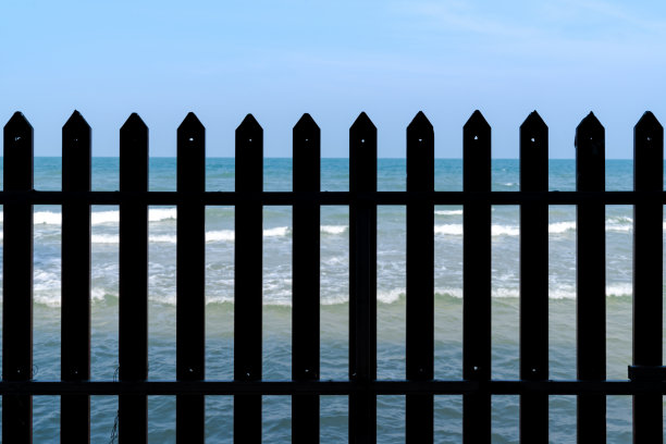 栅栏和蓝色波浪的大海图片下载