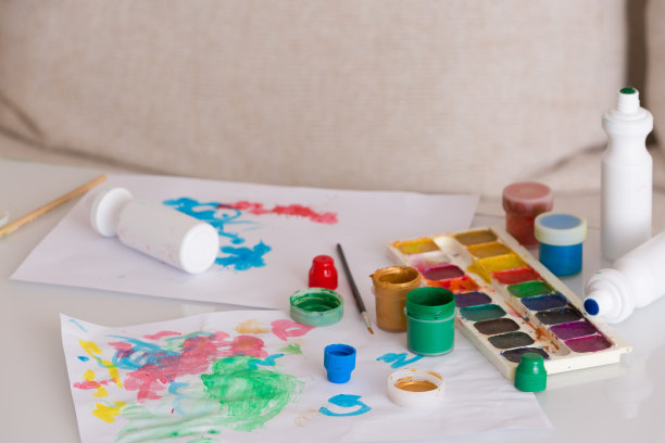 彩色的颜料，孩子们的画和画笔在桌子上。家里有创造力的孩子。图片下载