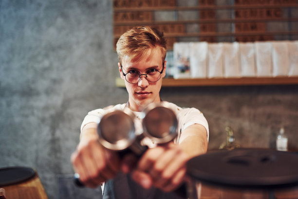 集中的照片。年轻男性在室内咖啡馆工作。业务和服务的概念图片下载