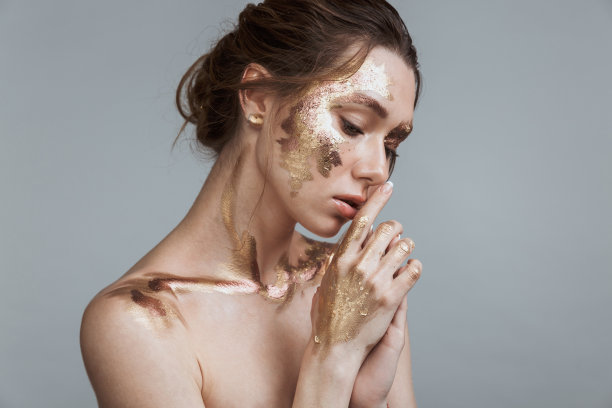 深色皮肤的女人，柔软健康的皮肤和金色的妆图片下载