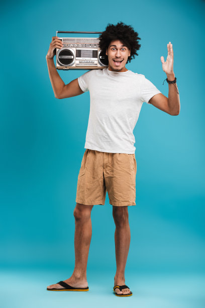 兴奋的年轻非洲卷发男子站在孤立图片下载