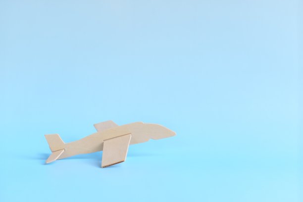 木制飞机模型起飞在天蓝色的背景。开始旅行的概念。图片下载