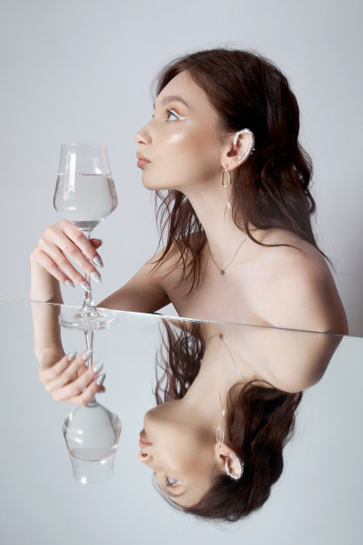 镜子里的女人，手里拿着镜子。美丽的脸妆，天然的化妆品图片下载