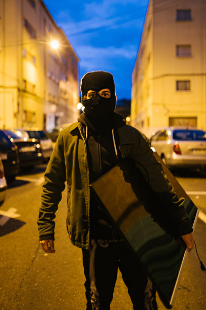 戴着面具晚上拿着偷来的电视机的小偷图片下载