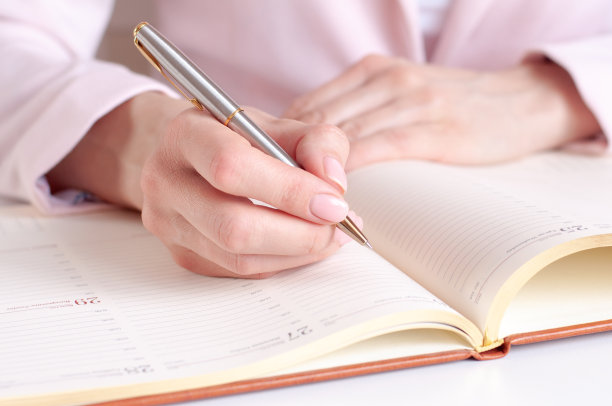 一个女人用钢笔在日记本上写下信息图片下载