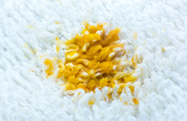 白色棉布毛巾或地毯上有脏的食物污渍。近距离的照片。图片下载