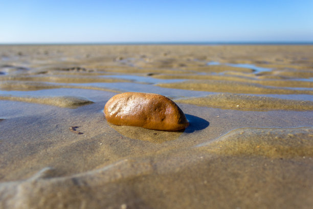 极简主义的观点，一个岩石在沙滩上的沙子图片下载