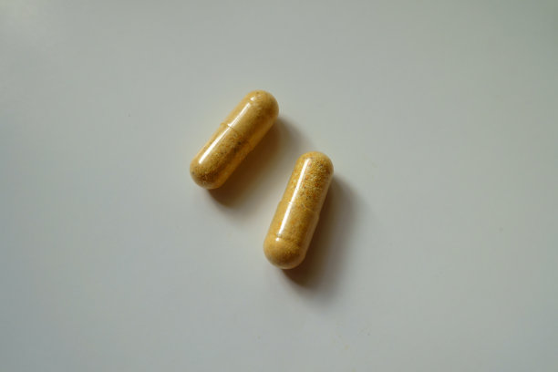 近距离拍摄的两个橙色的复合维生素纤维素胶囊图片下载