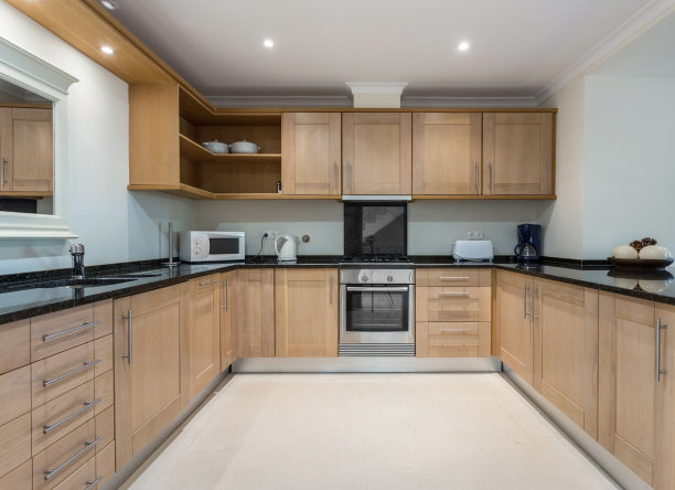 现代的棕色木制厨房，配有电器。欧洲酒店设计。图片下载