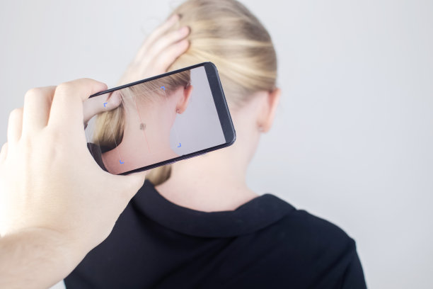 这名女子展示了他的脖子，植入了一个芯片，由一个特殊的设备读取或扫描。芯片和植入电子技术的概念。控制论和纳米未来。塞伯朋克图片下载