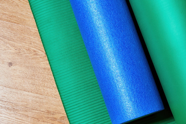 按摩健身滚轮和垫子在木地板上。运动健身和健康理念图片下载