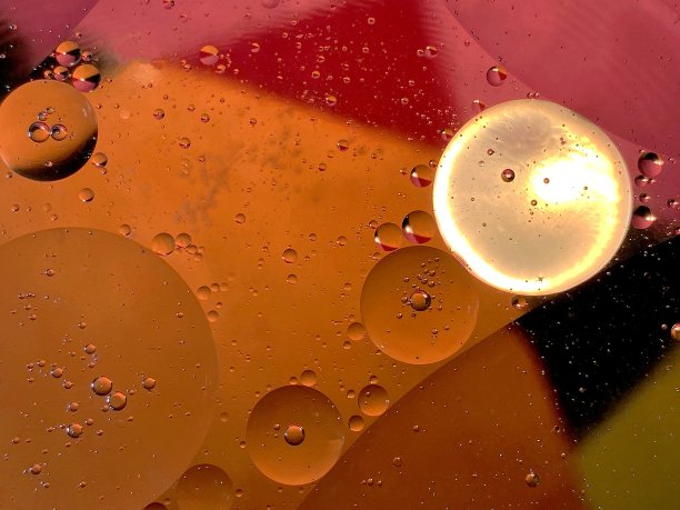 被照亮的浮在水面上的油滴图片下载