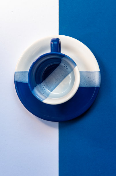 蓝白背景上的空咖啡杯和盘子。极简主义艺术图片下载