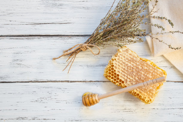 百里香蜂蜜概念，蜂房与干百里香束放在白色木桌上，健康食品图片下载