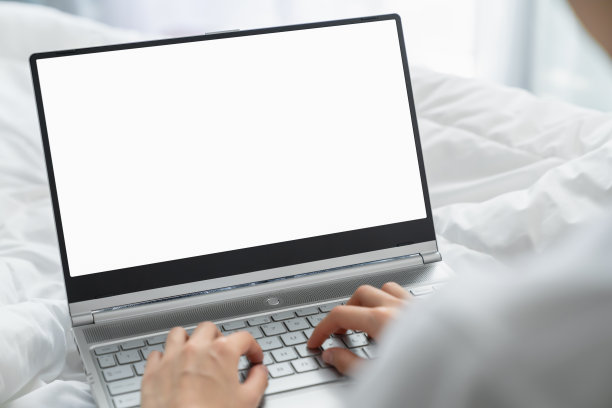 女人在卧室的床上用手提电脑打字。广告模型屏幕。图片下载
