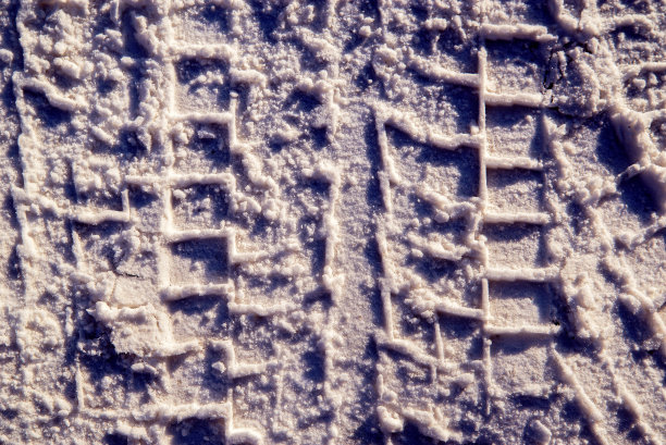 特写照片的道路在冬季。在肮脏的雪地上，从卡车的轮胎可以看到一个保护器图片下载