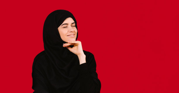 横幅,长格式。穿着黑色头巾的漂亮女人在红色背景下摆姿势，旁边是空白广告空间。图片下载