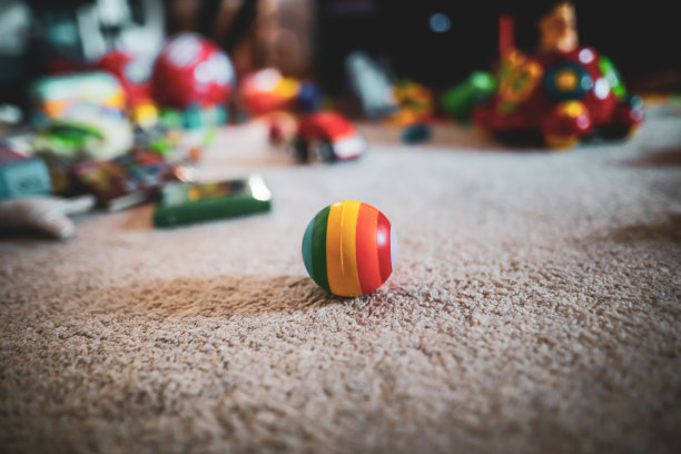 浅层景深(选择性聚焦)图像与彩色橡皮球在地板上的幼儿室，与玩具的背景。图片下载