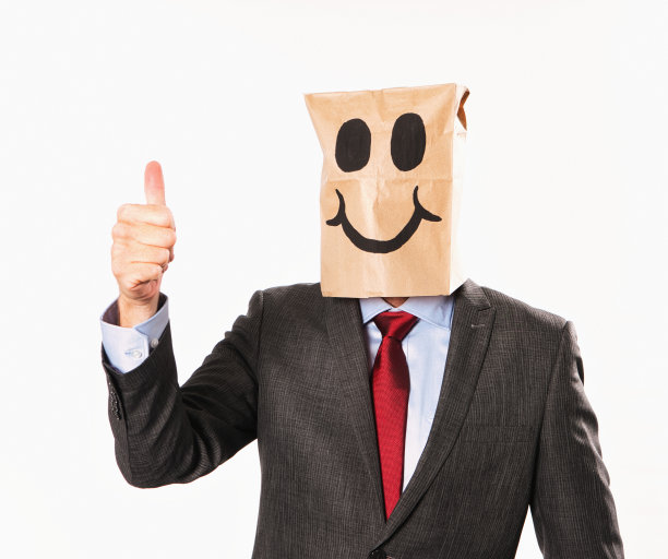 穿着西装的快乐商人，戴着卡通纸袋，竖起大拇指图片下载